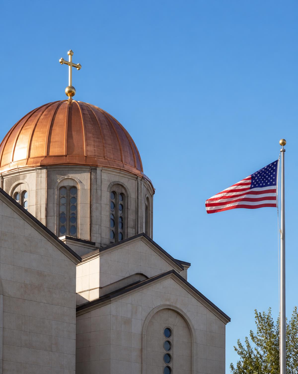 Copper dome of a Serbian Orthodox church in the United States beside an American flag